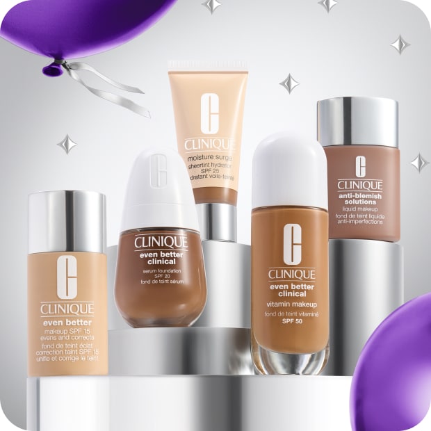 Selection of best-selling Clinique foundations on a grey plinth, surrounded by purple balloons